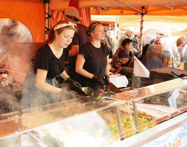 people serving food at food festival